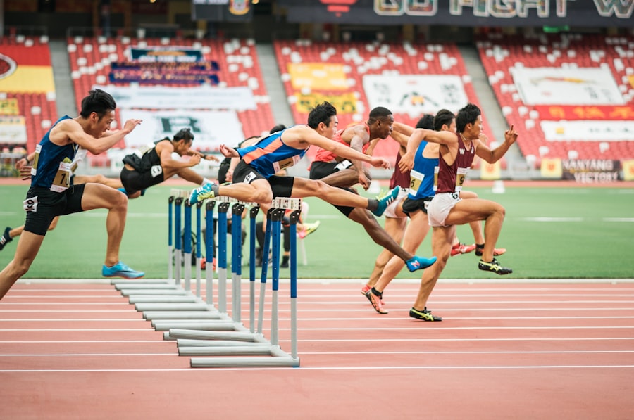 Athletes clearing hurdles during a race